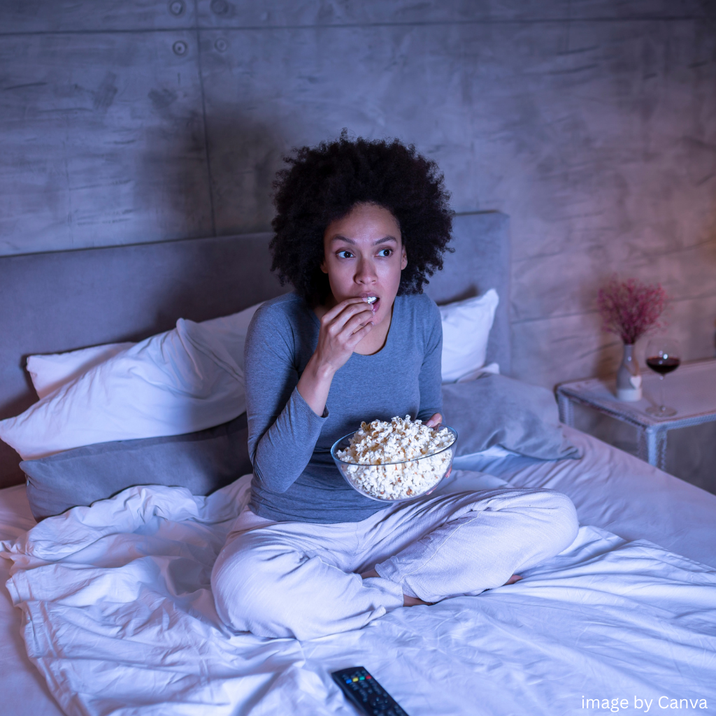 woman in bed watching a movie maybe wondering who the next james bond actor will be