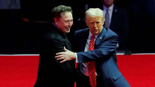 Elon Musk and Donald Trump hugging on stage