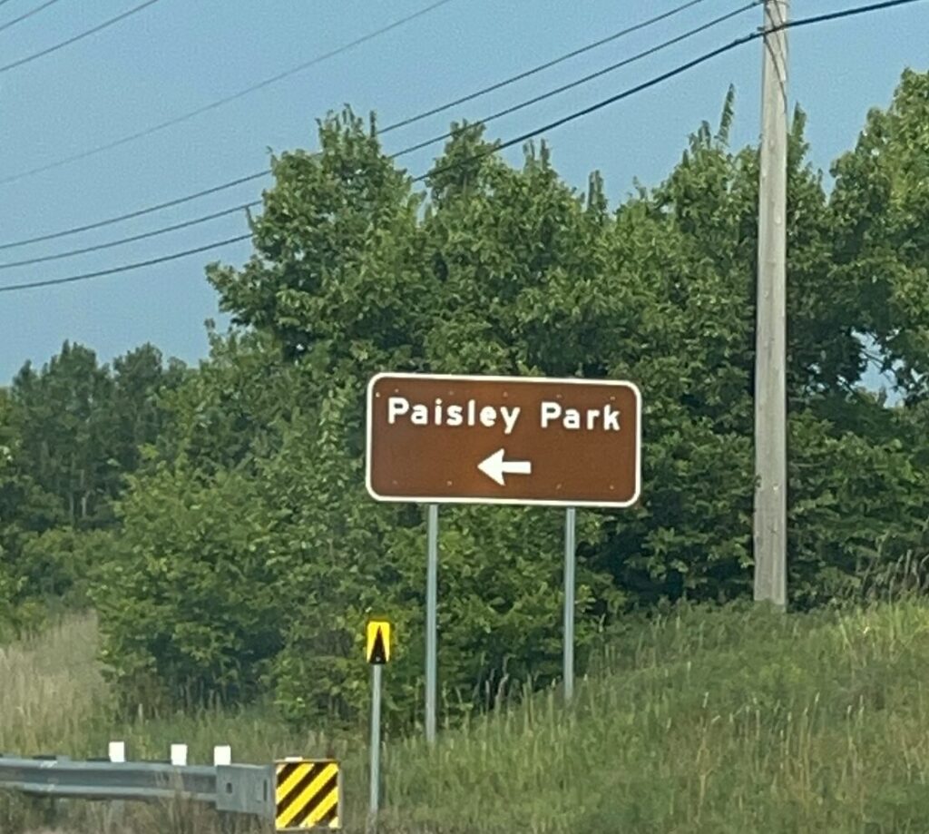 Paisley Park street sign with arrow pointing left.